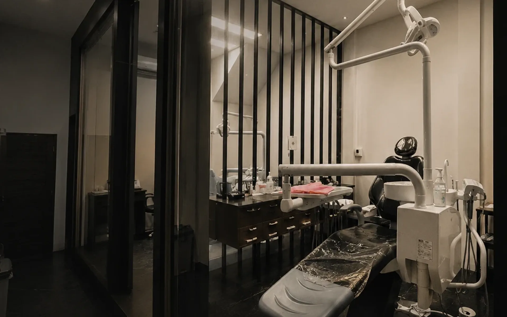 Ruang tindakan Klinik Kampoeng Gigi dengan dental chair, dinding kaca dan lampu langit-langit
